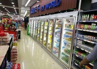 Sala fria da exposição da bebida fresca do supermercado, caminhada comercial na sala do congelador
